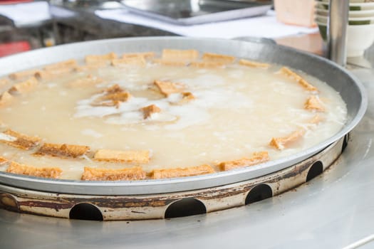 Big dish of tofu being boiled at a stall