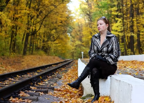 Toung women sits near a railroad in a park