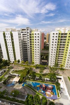 A high angle shot of a residential estate with roof facilities of garden and playground.