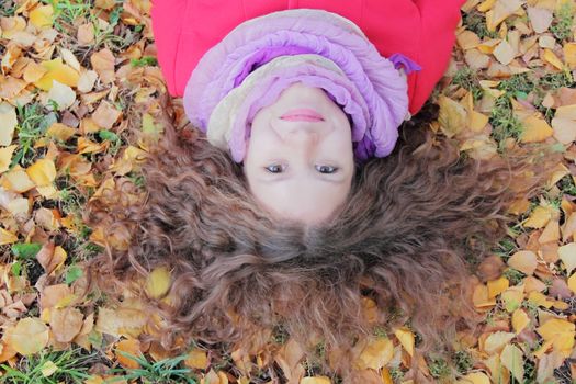 Image of beautiful young woman with autumn leaves