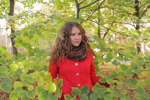 Portrait of thinking young woman in red coat