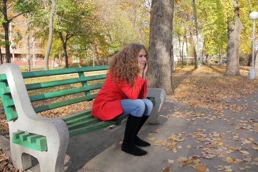 Portrait of thinking young woman in red coat