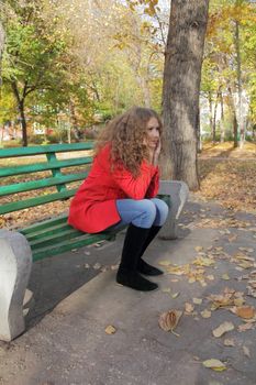 Portrait of thinking young woman in red coat