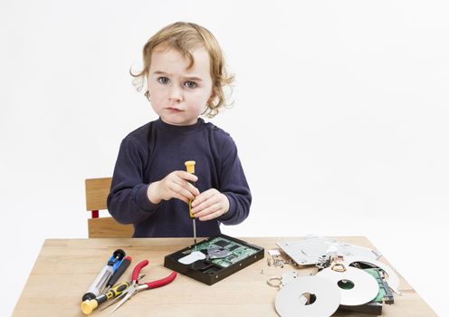 child repairing computer part. studio shot in light grey background