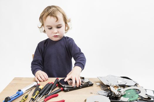 child repairing computer part. studio shot in light grey background