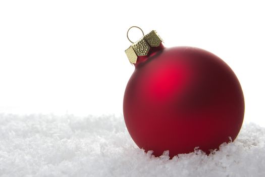 red christmas bauble on artificial snow 