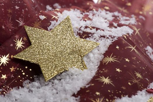 christmas, golden christmas star on snow with decoration 