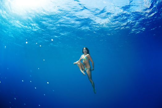 athletic girl diving under the sea