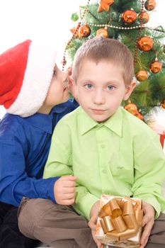 Boys with gift secretive on Christmas tree background