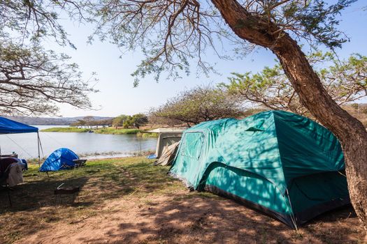 Holiday camping tents at dam lake side landscape.