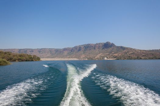 Ski-boat wake from engine propeller and hull on the dam waters