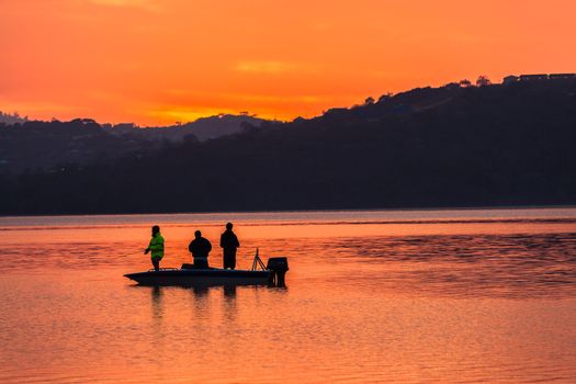 Dawn color reflections fishermen boat waters