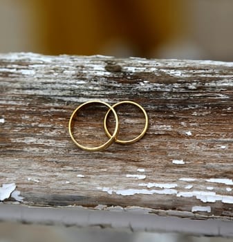 Wedding rings on the old wooden surface