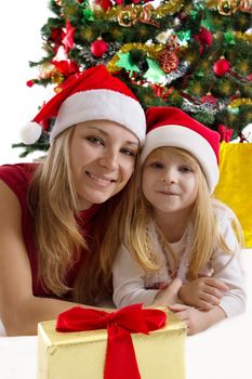 Mother and little daughter under Christmas tree