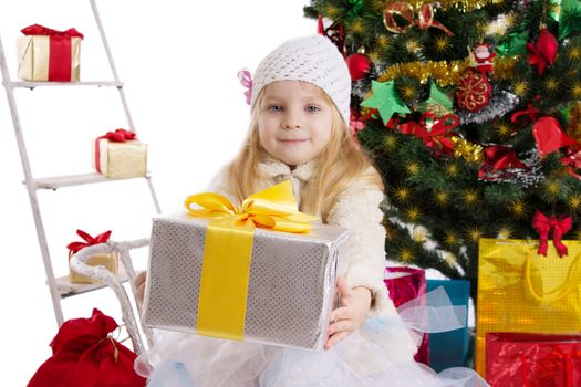 Cute blonde girl with present under Christmas tree