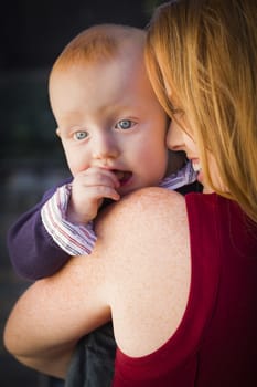 Adorable Red Head Infant Boy Portrait with His Mother Outdoors in Dramatic Lighting.