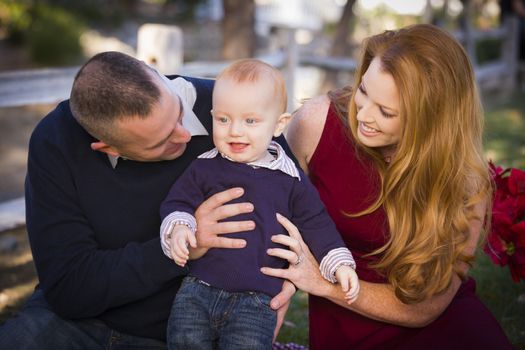 Adorable Infant Boy and Young Military Parents Play Together in the Park.