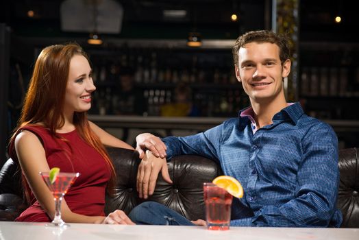 Young couple talking in a nightclub, have fun