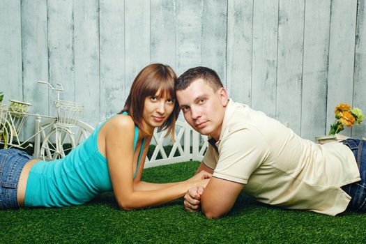Young, happy married couple relaxing on the lawn and enjoys