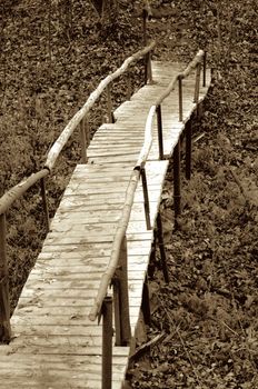 Old Rustic Wooden Foot Bridge in Ravine Outdoors. Toned