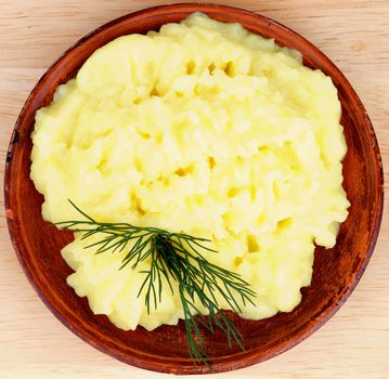 Homemade Mashed Potato in Brown Bowl Garnished with Dill. Top View