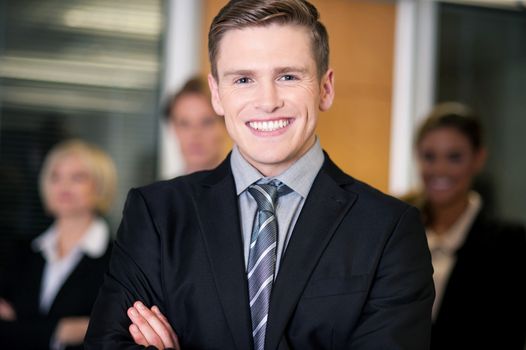 Businessman posing with smart associates behind