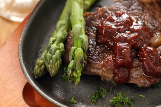 Fresh cooked asparagus with beef steak and ketchup.