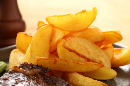 Crisp Golden potato wedges served with steak and ready to eat.