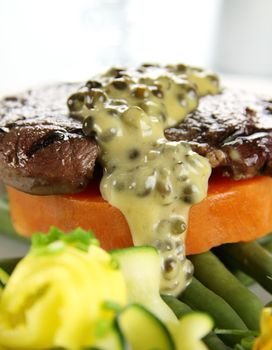 Chargrilled steak on sweet potato with green peppercorn sauce.