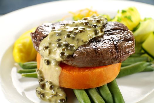 Chargrilled steak on sweet potato with green peppercorn sauce.