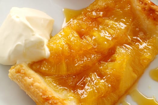 Delicious spiced pineapple galette served with cream .