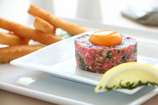 Delicious steak tartare with raw egg with lemon ready to serve.