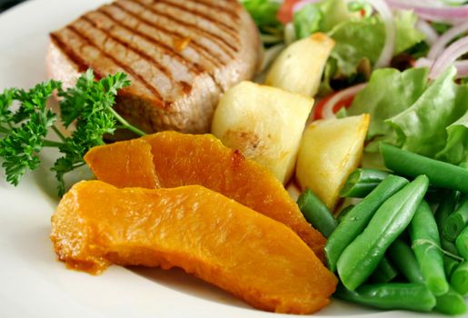 Hearty dinner of steak, vegetables and a side salad.