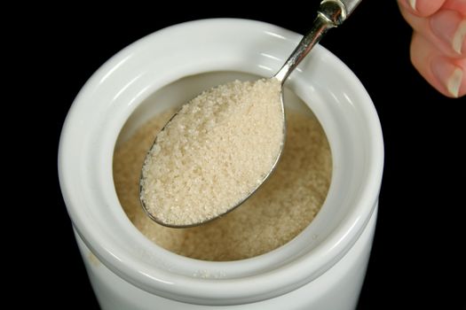 Spoonful of raw sugar ready to serve.