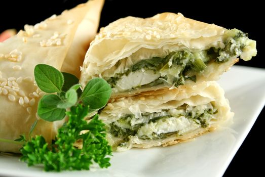 Spinach and feta cheese triangles with garnish.