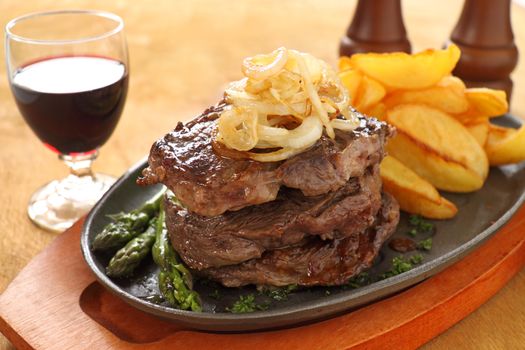 Grilled triple decker rib fillet steak with fried chips ready to serve.