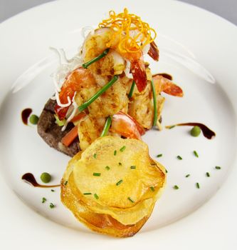 Delicious chargrilled steak with grilled shrimps, vegetables and potato chip stack.