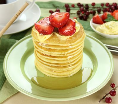 Delicious strawberry pancake stack stack dripping with honey.