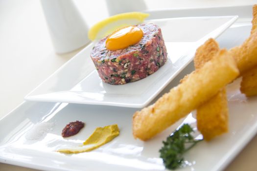 Delicious steak tartare with raw egg with lemon ready to serve.