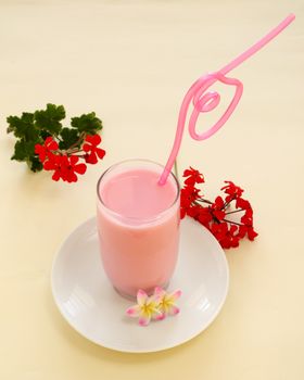 Sweet strawberry milk with a pink curved straw.