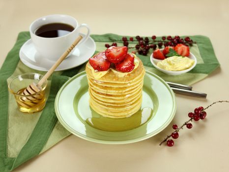 Delicious strawberry pancake stack stack dripping with honey with cream.