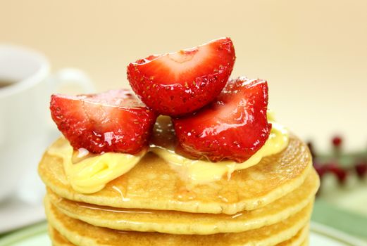 Delicious strawberry pancake stack stack dripping with honey with cream.