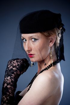 portrait od a young woman in hat with veil and gloves