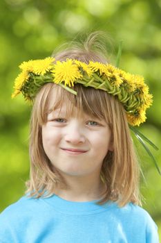 portrait of a boy with long blond hair wearing a flower wreath