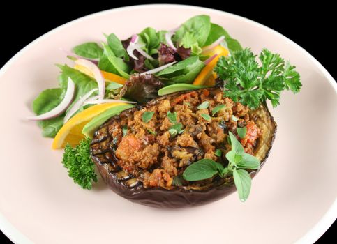 Egg plant stuffed with bolognaise with side salad and garnish.