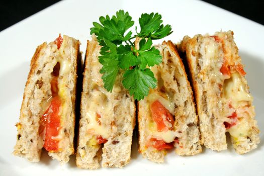 Yummy toasted cheese and tomato sandwiches with mustard.