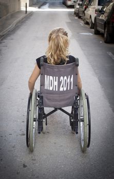 A girl sitting in a wheelchair with her back to the camera