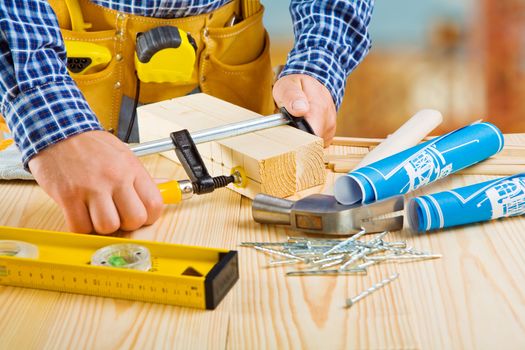 hands of carpenter do fixing of wooden planks