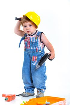 Little builder. Baby boy in a helmet plays in the builder with tools. Isolated over white.