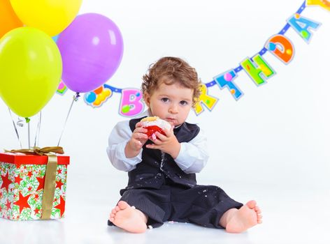 Babies' first birthday one year old with colorful balloons. Isolated over white.